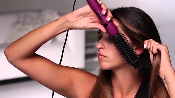  Момичето изсушава косата си със сешоар