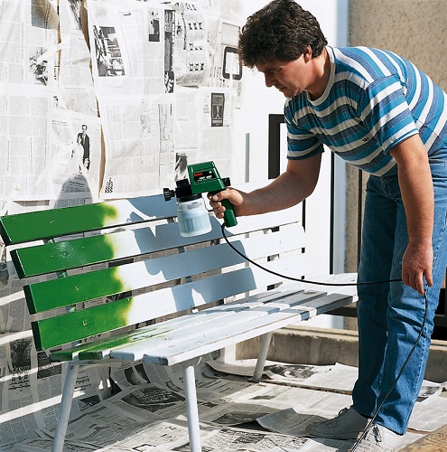  Един мъж рисува пейка с пясък